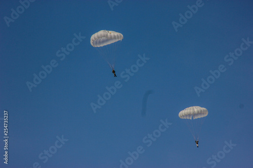 skydiver on blue sky white dome paratrooper