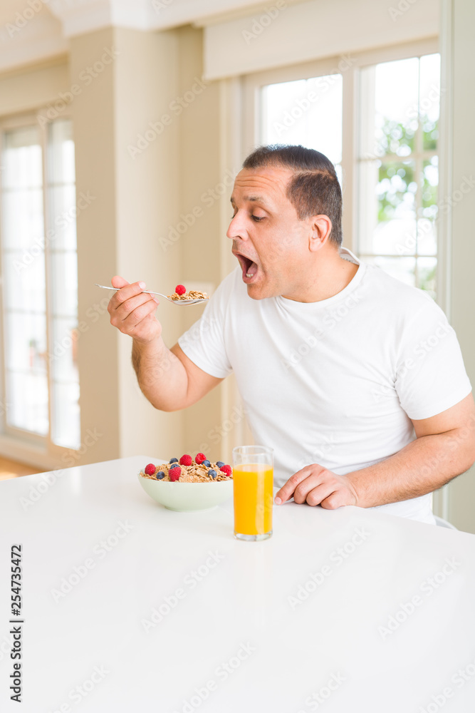 Middle age senior man eating healthy cereals for breakfast Middle age senior man eating healthy cereals for breakfast