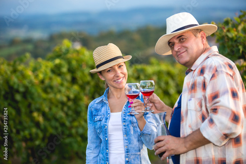 Couple in Vineyard Harvesting Grapes and tasting vine © romul014