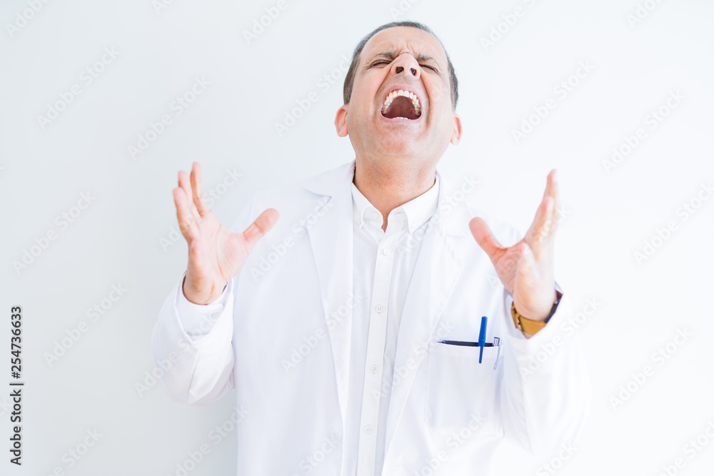 Middle age doctor man wearing medical coat over white background celebrating mad and crazy for success with arms raised and closed eyes screaming excited. Winner concept Middle age doctor man wearing medical coat over white background celebrating mad and crazy for success with arms raised and closed eyes screaming excited. Winner concept