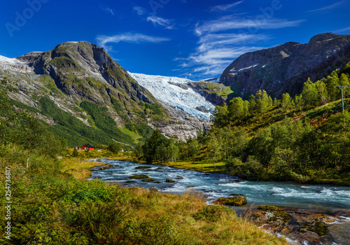 Norwegian landscape with milky blue glacier river, glacier and green mountains. Norway © Max Topchii