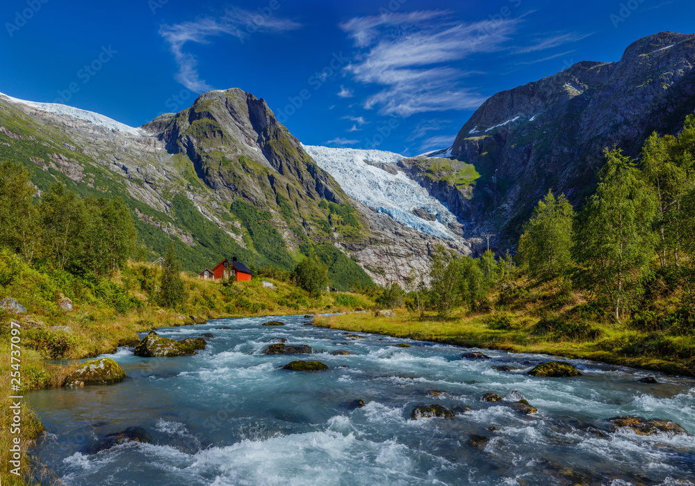 Norwegian landscape with milky blue glacier river, glacier and green mountains. Norway