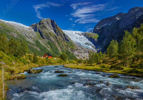 Fototapeta Naklejka Na Ścianę i Meble -  Norwegian landscape with milky blue glacier river, glacier and green mountains. Norway