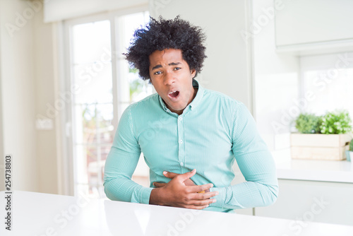 African American business man wearing elegant shirt with hand on stomach because indigestion, painful illness feeling unwell. Ache concept.