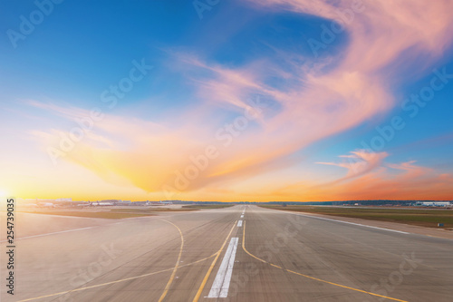 Empty runway at evening airport during sunset