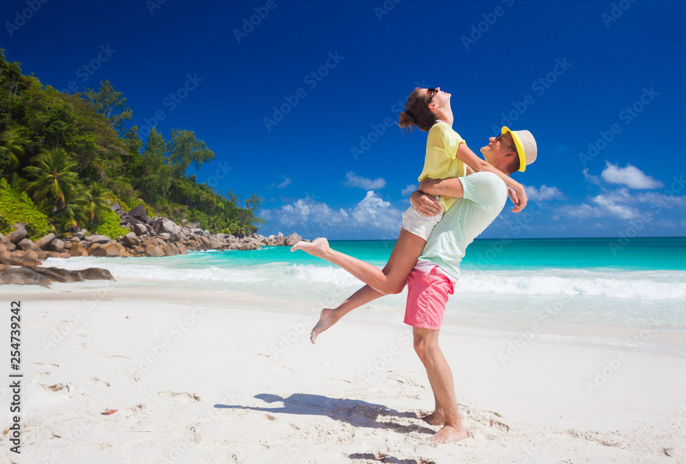 happy young couple in bright clothes having fun by the beach happy young couple in bright clothes having fun by the beach