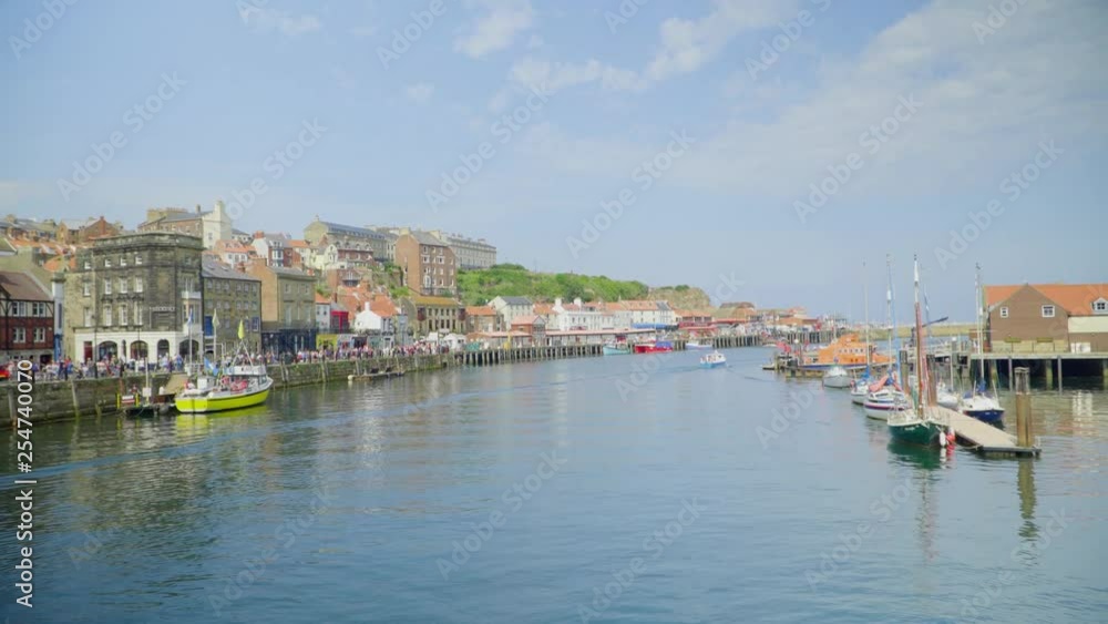 Crossing a bridge over a river in a small fishing town. Summer in the UK with lots of tourists. Crossing a bridge over a river in a small fishing town. Summer in the UK with lots of tourists.