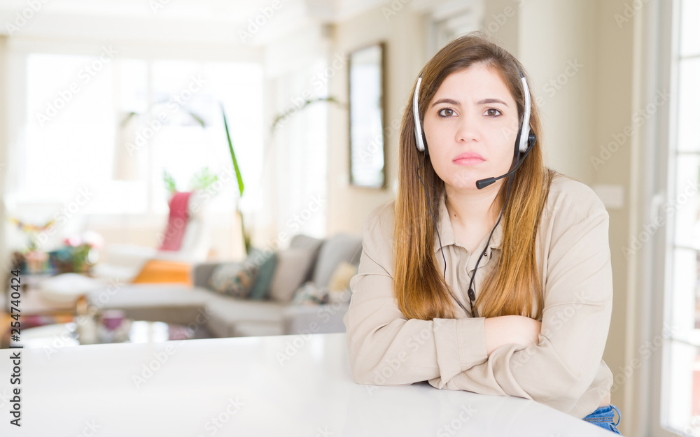 Beautiful young operator woman wearing headset at the office skeptic and nervous, disapproving expression on face with crossed arms. Negative person. Beautiful young operator woman wearing headset at the office skeptic and nervous, disapproving expression on face with crossed arms. Negative person.
