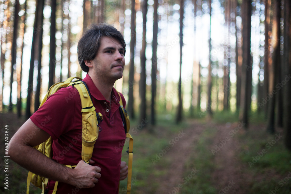 Hiker - man hiking in forest. Male hiker looking to the side walking in forest. Caucasian male model outdoors in nature. Hiker - man hiking in forest. Male hiker looking to the side walking in forest. Caucasian male model outdoors in nature.