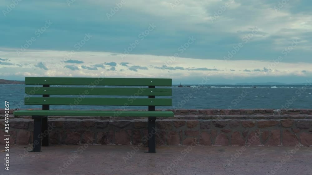 Green bench rough sea dramatic sky Green bench rough sea dramatic sky