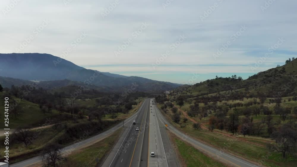 Aerial View Hovering Over Highway in Misty Green Mountains, Early Morning Aerial View Hovering Over Highway in Misty Green Mountains, Early Morning