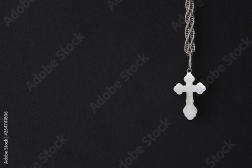 silver orthodox cross hanging on a chain on a black background  © Снежана Кудрявцева