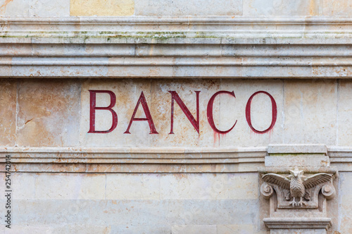 Bank word in Spanish sculpted in stone and red color. Old look