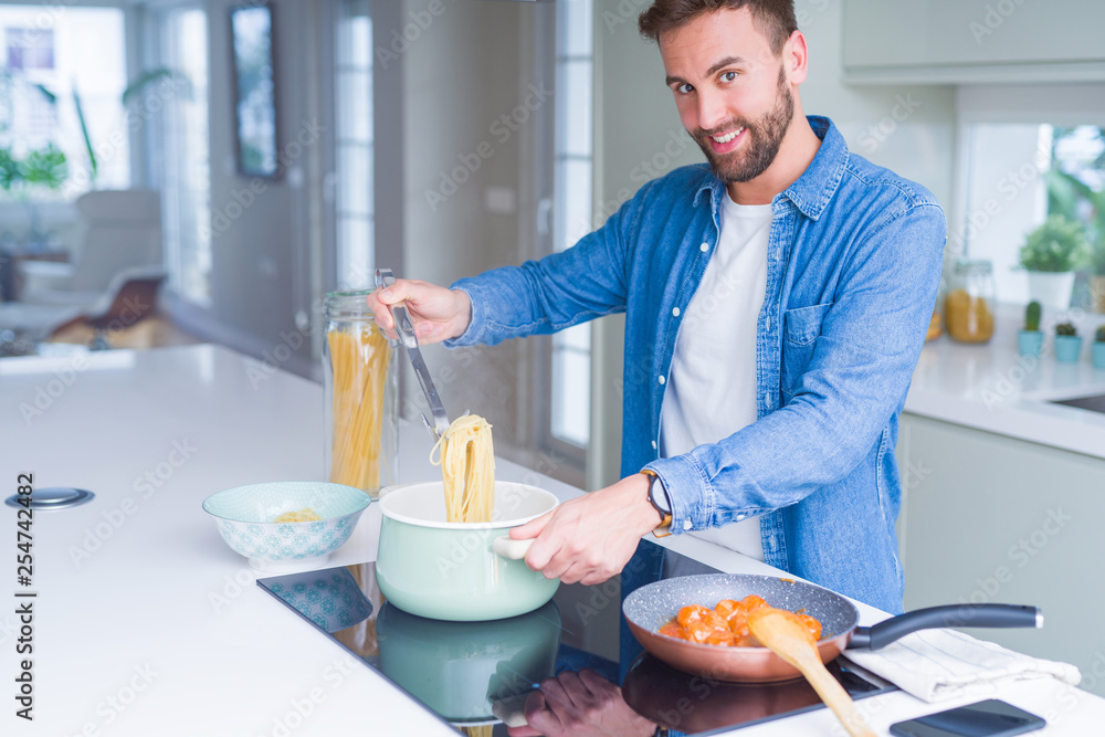 Handsome man cooking pasta at home Handsome man cooking pasta at home