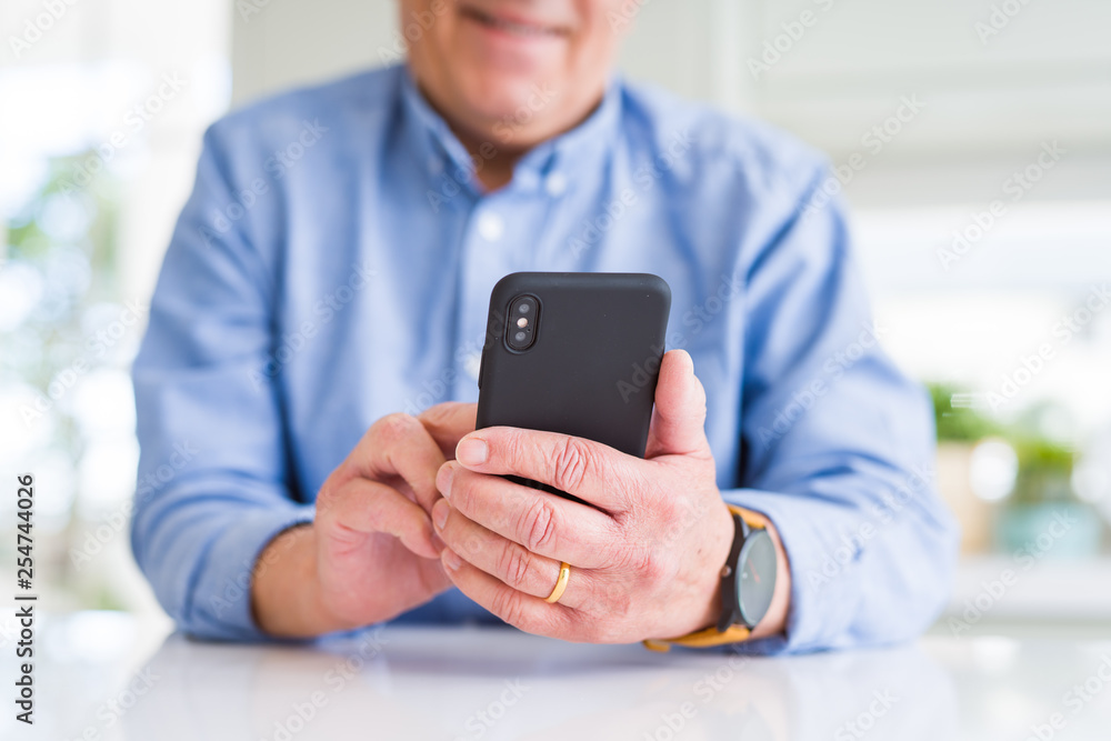 Close up of man hands using smartphone and smiling confident Close up of man hands using smartphone and smiling confident