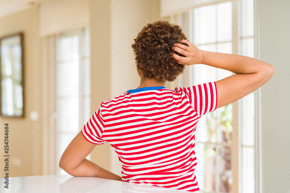 Young beautiful african american woman at home Backwards thinking about doubt with hand on head Young beautiful african american woman at home Backwards thinking about doubt with hand on head