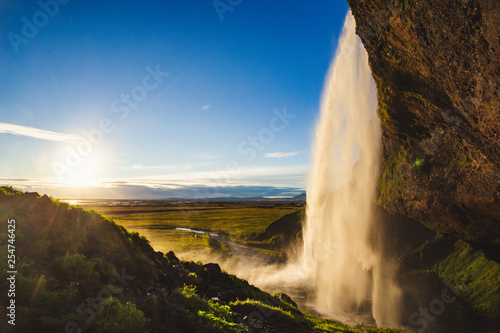 Beautiful seljalandsfoss most famous waterfall in Iceland during a magnificent blue sky sunset in summer with option to walk behaind into small cave