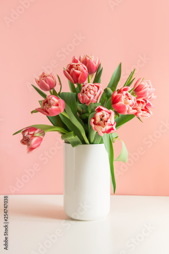 Fototapeta Naklejka Na Ścianę i Meble -  Bouquet of red tulip in vase on millennial pink.