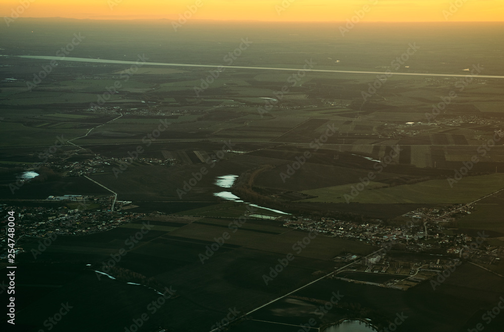 Panorama of the evening city at sunset from the window of the plane