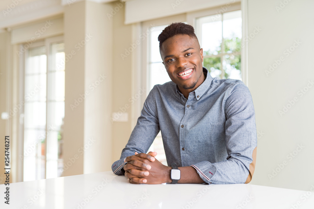 Handsome african american man on white table with a happy and cool smile on face. Lucky person. Handsome african american man on white table with a happy and cool smile on face. Lucky person.