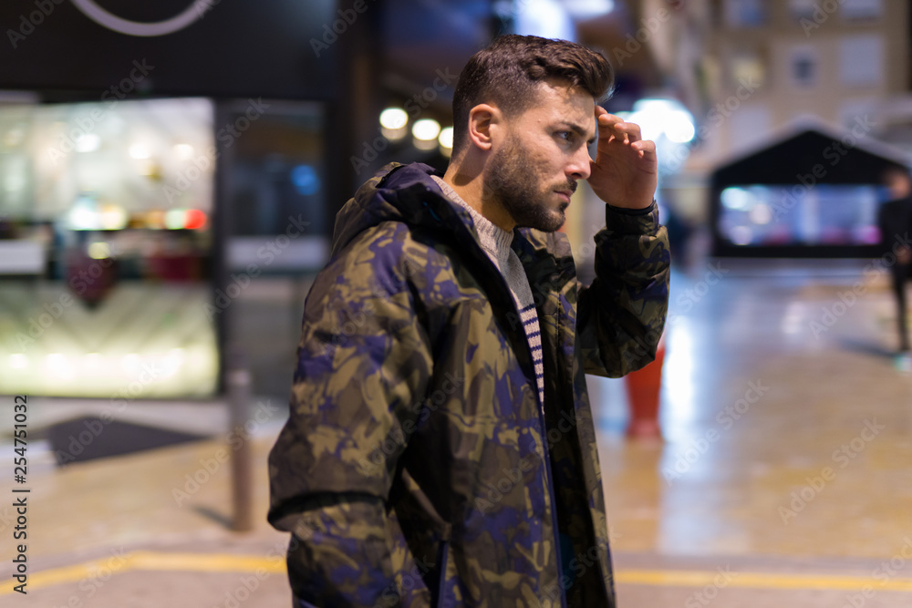 Young handsome man possing and smiling. Street style at night Young handsome man possing and smiling. Street style at night