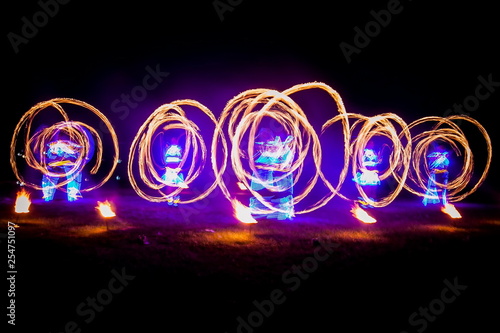 Amazing fire show dance. Fire dancers in beautiful costumes playing with colorful flames