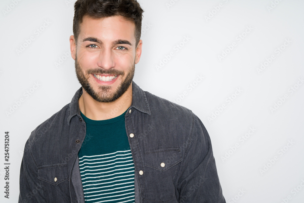 Young handsome man possing and modeling over grey isolated background ...