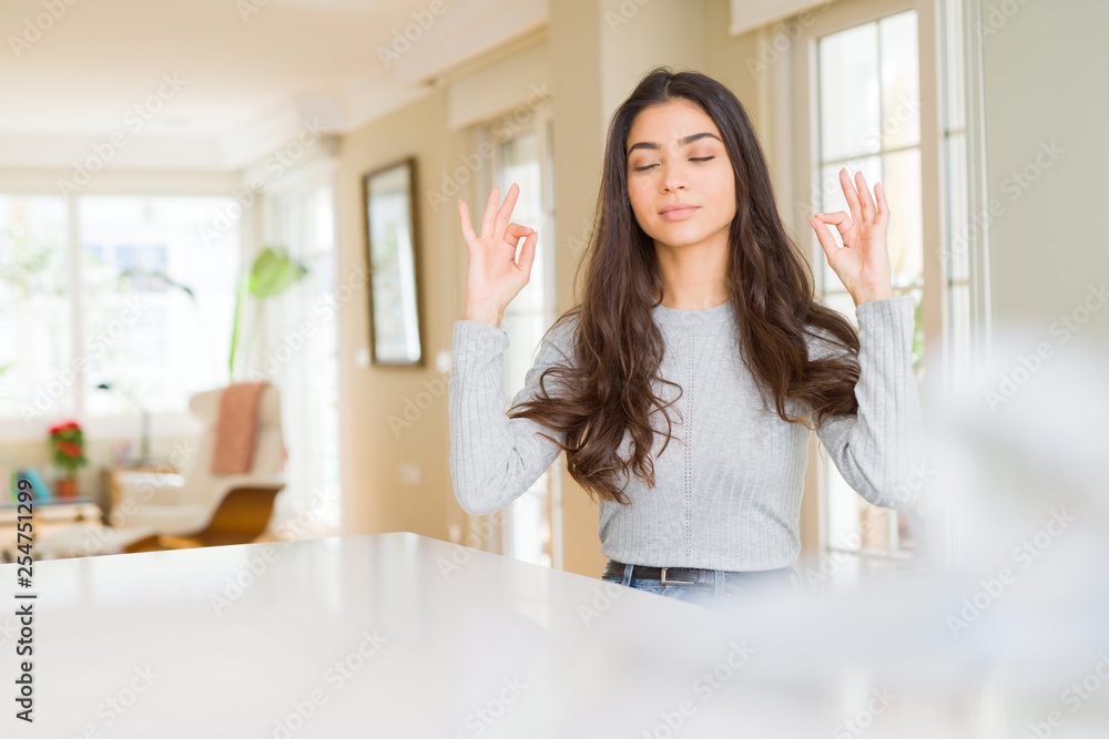 Young beautiful woman at home relax and smiling with eyes closed doing meditation gesture with fingers. Yoga concept. Young beautiful woman at home relax and smiling with eyes closed doing meditation gesture with fingers. Yoga concept.