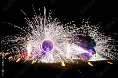 Amazing fire show dance. Fire dancers in beautiful costumes playing with colorful flames