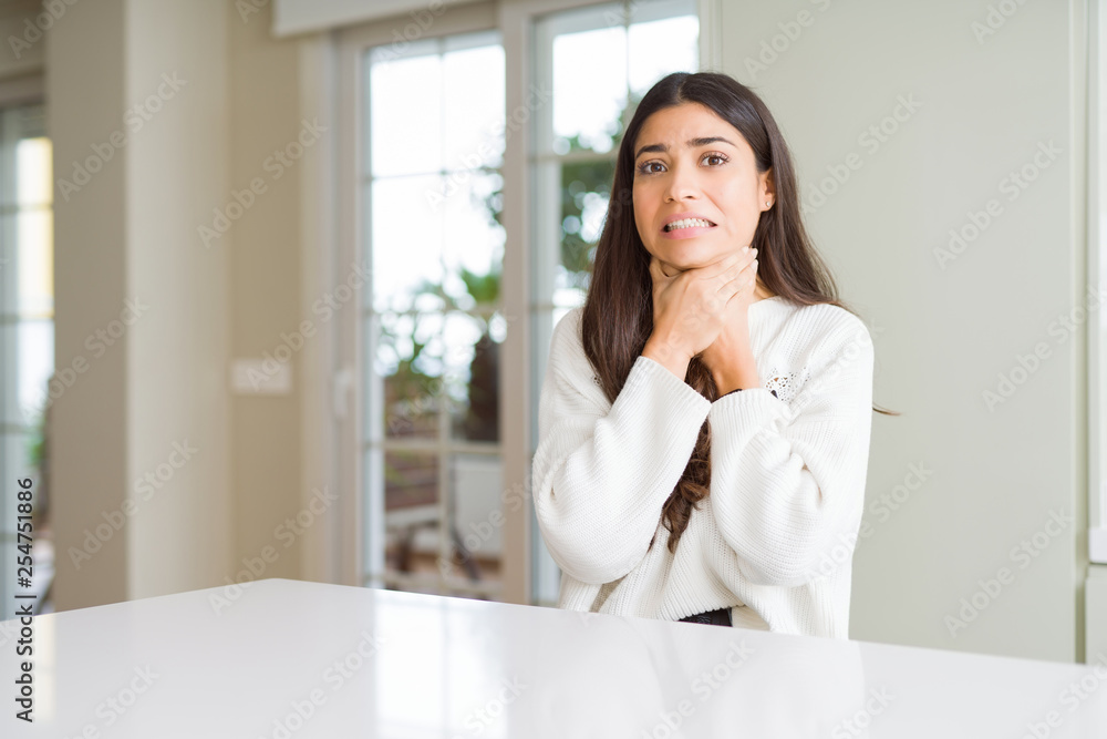 Young beautiful woman at home on white table shouting and suffocate because painful strangle. Health problem. Asphyxiate and suicide concept. Young beautiful woman at home on white table shouting and suffocate because painful strangle. Health problem. Asphyxiate and suicide concept.