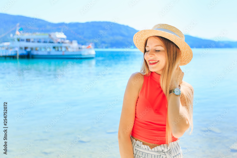 close-up of a girl with boater closed her eyes and smile. lake,