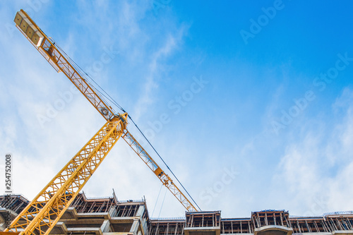 Obraz na plátně construction site and yellow crane on the background blue sky