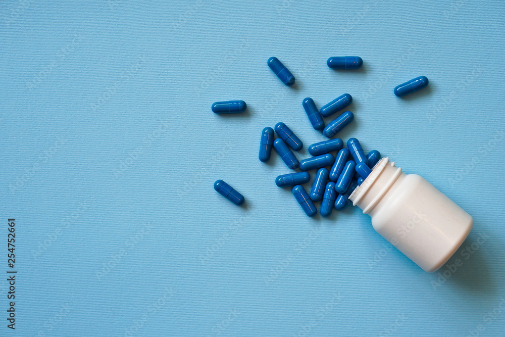 Assorted pharmaceutical medicine pills, tablets and capsules and bottle on blue background. Drugs and various narcotic substances. Copy space for text. Stock photo for design Assorted pharmaceutical medicine pills, tablets and capsules and bottle on blue background. Drugs and various narcotic substances. Copy space for text. Stock photo for design