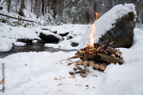 Campfire on snow in the winter forest
