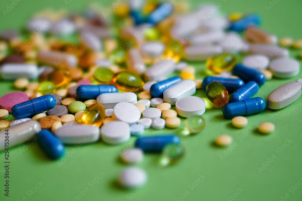 Assorted pharmaceutical medicine pills, tablets and capsules and bottle on purple background. Drugs and various narcotic substances. Copy space for text. Stock photo for design Assorted pharmaceutical medicine pills, tablets and capsules and bottle on purple background. Drugs and various narcotic substances. Copy space for text. Stock photo for design