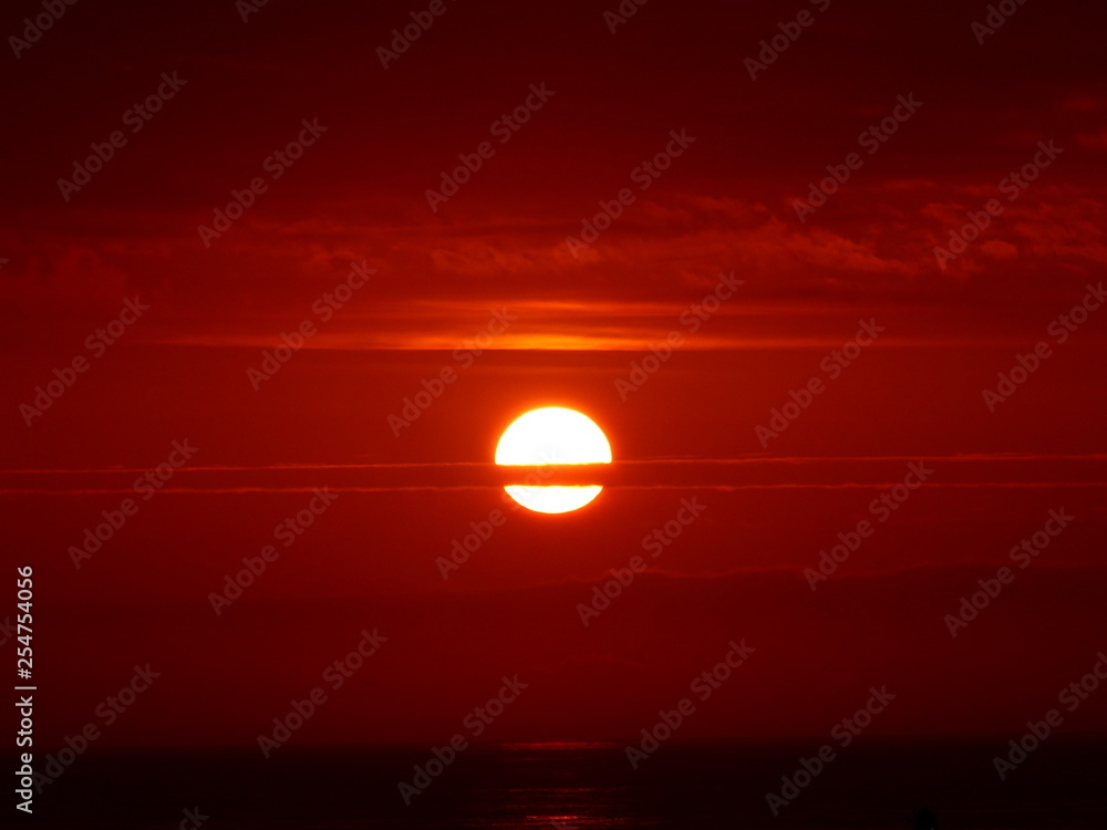 Sonnenaufgang in orange mit Wolkenstreifen am Meer