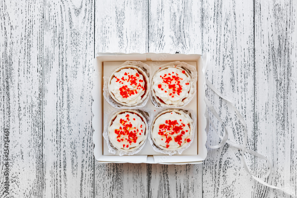 Four cake cakes in a box on white old vintage boards background Four cake cakes in a box on white old vintage boards background