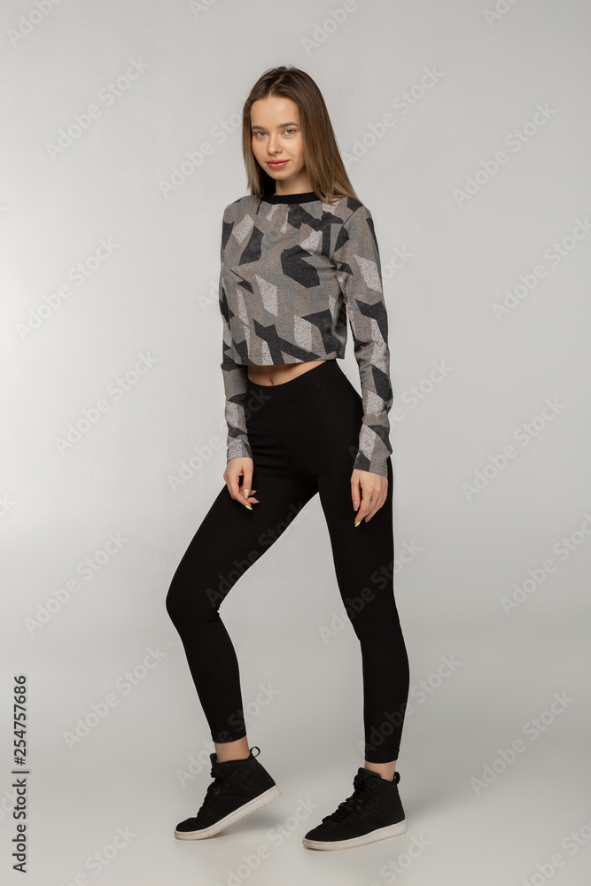 Attractive cute female fitness instructor dressed in black sportwear Attractive cute female fitness instructor dressed in black sportwear