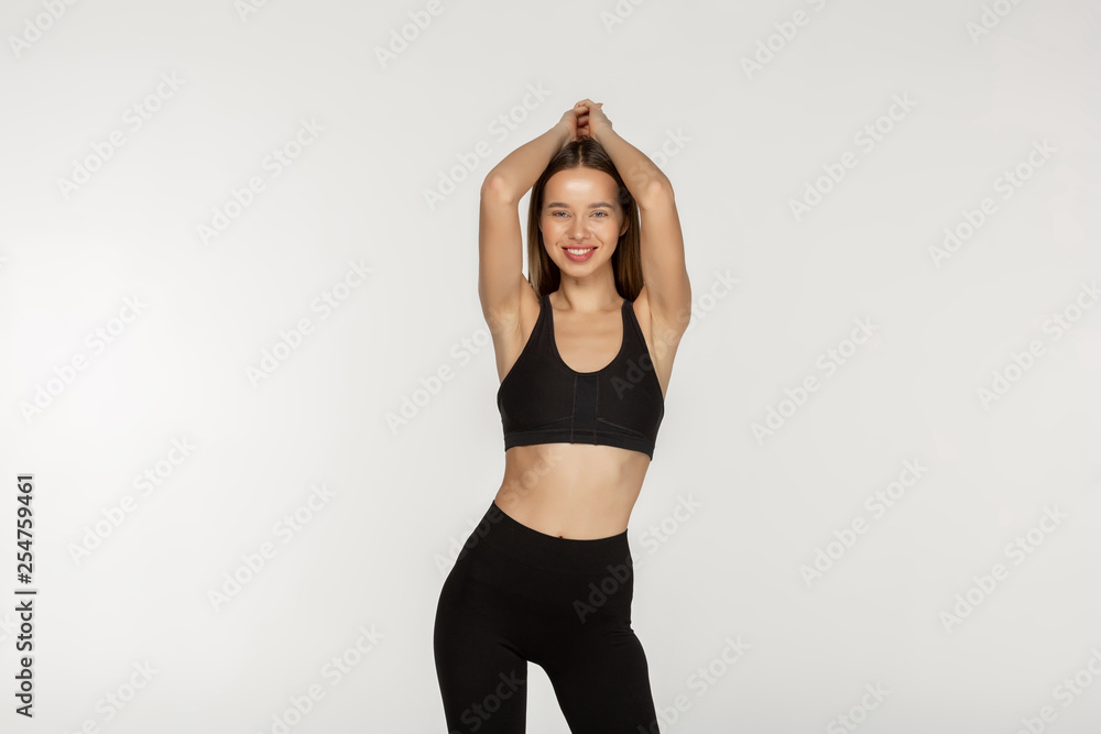 Young slim girl in a black tight suit for yoga and fitness