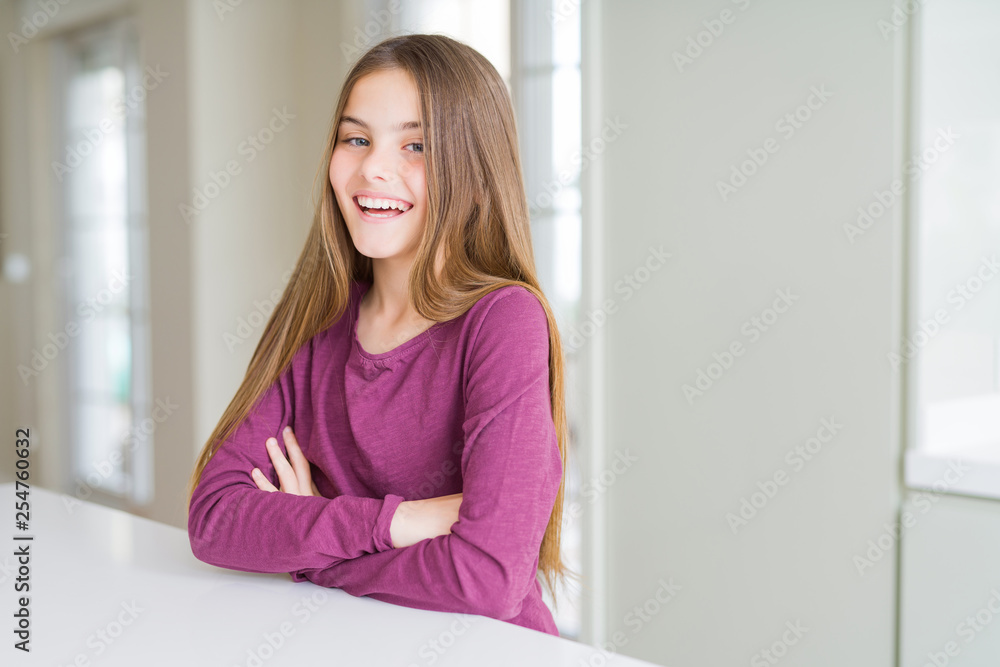 Beautiful young girl kid on white table happy face smiling with crossed arms looking at the camera. Positive person. Beautiful young girl kid on white table happy face smiling with crossed arms looking at the camera. Positive person.