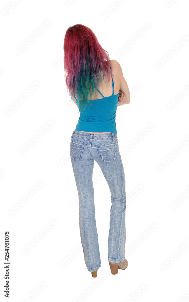 Slim young woman standing from back in jeans Slim young woman standing from back in jeans