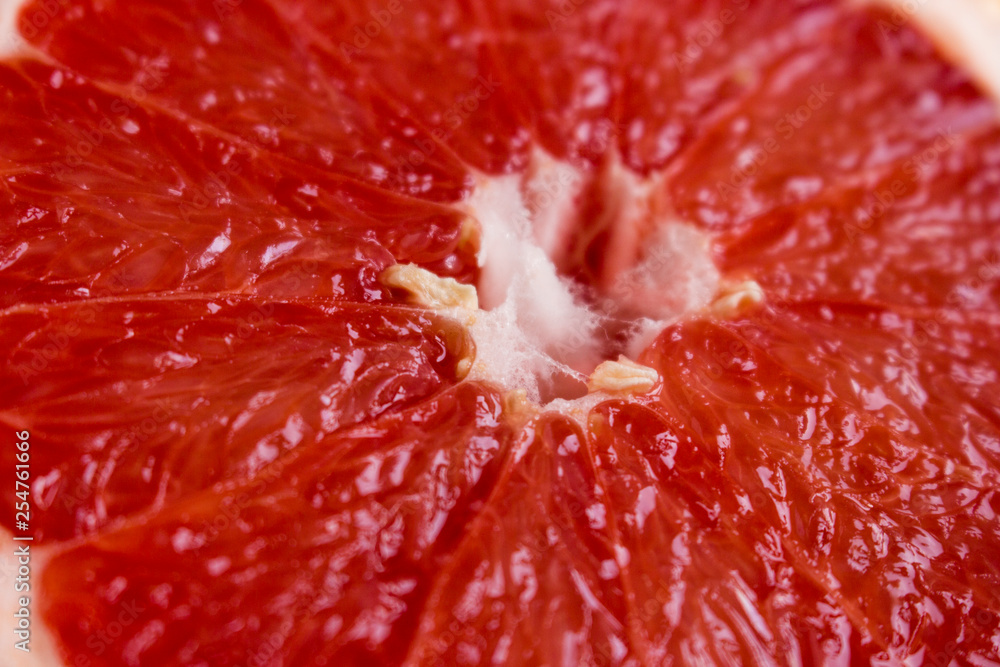 Red grapefruit flesh, close-up, background. Half a grapefruit with juicy pulp