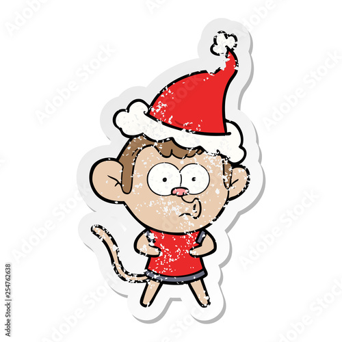 distressed sticker cartoon of a surprised monkey wearing santa hat