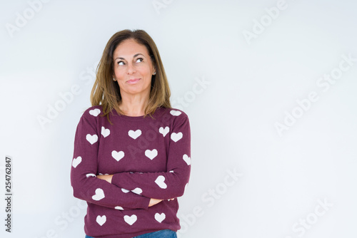 Beautiful middle age woman wearing heart sweater over isolated background smiling looking side and staring away thinking.