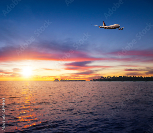 Beautiful sunset on Maldives resort with airplane © Jag_cz