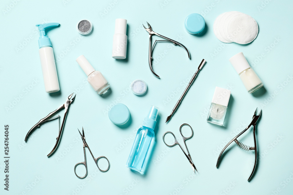 A set of cosmetic tools for manicure and pedicure on a blue background. Gel polishes, nail files and clippers, and the lamp top view Place for text. Top view. Flat lay A set of cosmetic tools for manicure and pedicure on a blue background. Gel polishes, nail files and clippers, and the lamp top view Place for text. Top view. Flat lay