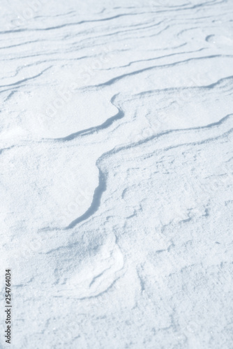 Fresh snow background texture. Winter background with snowflakes and snow mounds. Snow lumps.