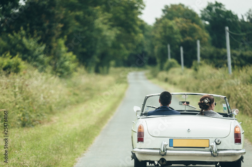 Couple strolling by convertible old car