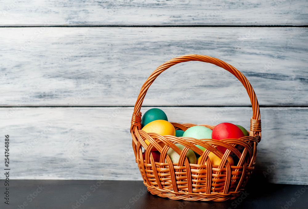 Easter eggs in a basket on a wooden background Easter eggs in a basket on a wooden background