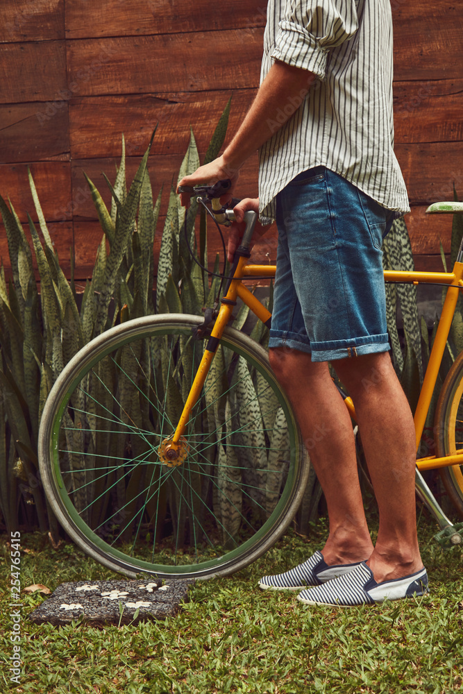 Naklejka premium Attractive man standing with old bicycle.